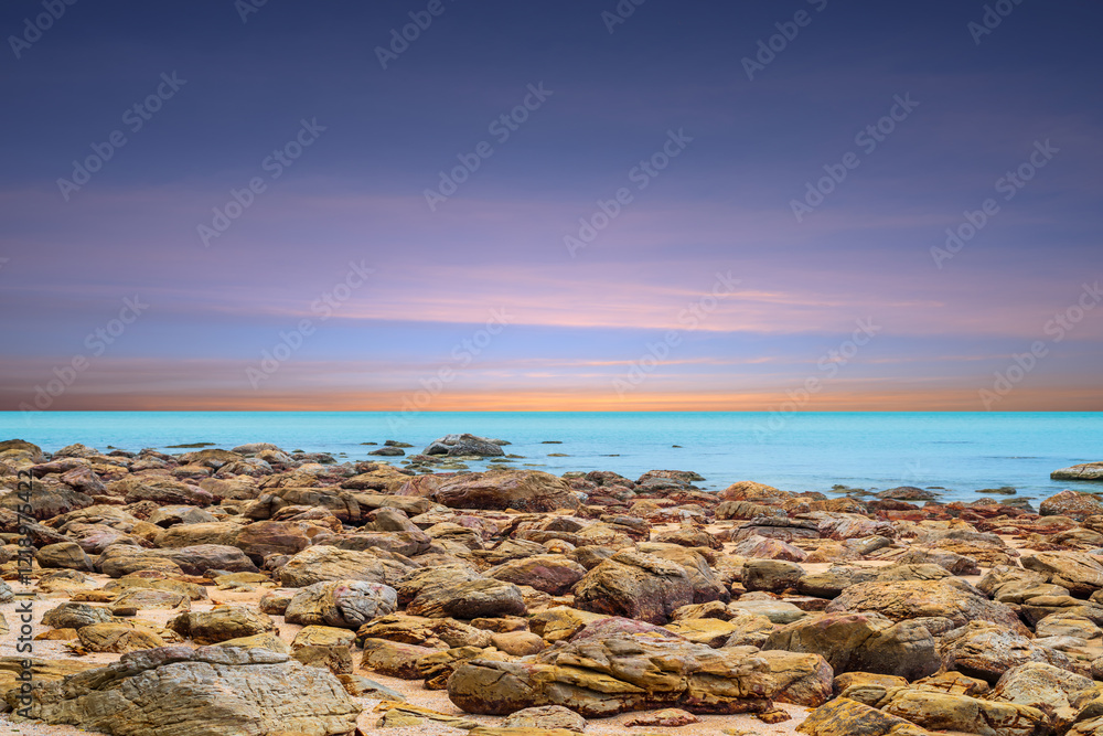 Wall mural beautiful seascape on sunset sky. panoramic landscape of rocky coast and sea. sea surface in sun lig