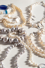 Pearl jewelry on white background. Necklace or bracelet. Different types of natural pearls. Vertical