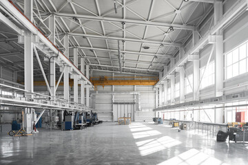 Yellow overhead traveling gantry crane beam on the pillars and truss ceilings of industrial building. Crane runway girder and metal structures. Interior of industrial storehouse or hangar