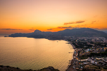 Picturesque view of sunset over the embankment of the city of Sudak in the mountainous area of...
