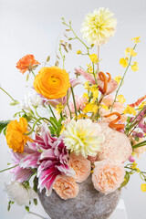 Cheerful floral arrangement with vibrant yellow dahlias, pink lilies, orange ranunculus, and pink roses, perfect for Valentine’s Day and Women’s Day