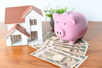 豚の貯金箱と住宅の模型のイメージ
