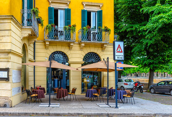Old street with tables of  restaurant in Verona, Italy. Architecture and landmark of Verona. Cozy...