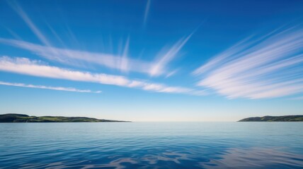 A serene ocean view captures a tranquil scene with gentle waves reflecting a vibrant sky filled with wispy clouds.