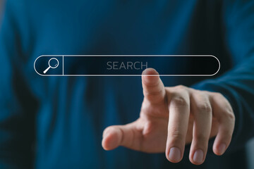 Close-up of a person pointing at a virtual search bar interface, symbolizing internet browsing,...