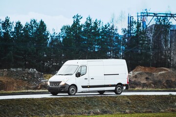Transport van on country road near factory buildings
