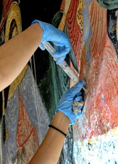 Restorer paintings on frescoes of religious motifs in Orthodox Christian monasteries