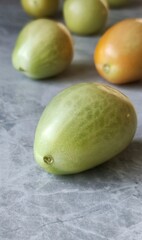 Small green tomatoes on a table under the concrete.