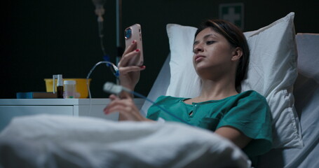 Hospitalized young woman with oxygen tube in her nose, engaged in a video chat.