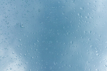 Raindrops on the window glass with dark clouds background