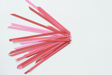 thin paper stripes in a variety of pinks and reds randomly arranged on paper
