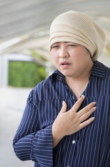 Unwell middle aged woman cancer patient wearing cancer cap, suffering from symptom relapse or...
