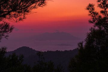 A breathtaking sunset over the Aegean Sea overlooking the Turkish coast of Marmaris. The rich hues of the sky and the silhouettes of the islands create an atmosphere of peace and harmony. Rhodos.