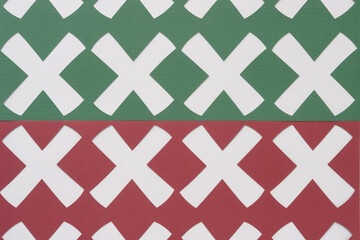 X shapes machine-cut from red and green paper on blank paper