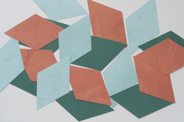 abstract paper diamond shapes in blue, green, and brown, on blank paper