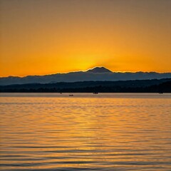 Naklejka premium A serene sunrise over Lake Llanquihue, with soft hues reflecting on the water and Osorno Volcano in the background. 