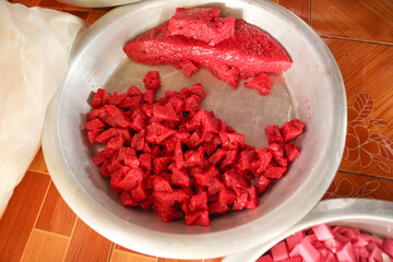 Burmese sweets are placed in large stainless steel containers to make merit. The snacks are placed in a container and cut into small and large square shapes, ready to eat.