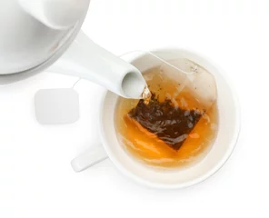 Fototapeten Pouring hot water into cup with tea bag on white background, top view © New Africa