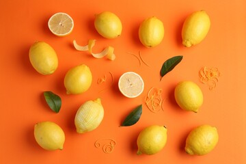 Lemon zest, fresh fruits and leaves on orange background, flat lay
