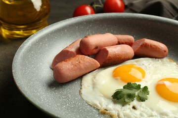 Tasty fried eggs and sausages served on grey table, closeup