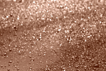 Water drops on glass surface, closeup. Toned in trendy color of 2025 year - mocha mousse