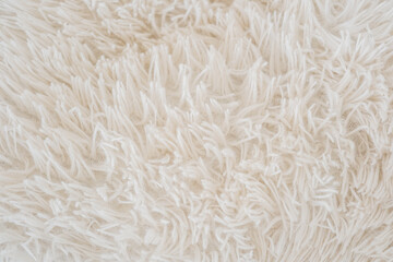Soft white textured fabric with fluffy strands in cozy interior setting