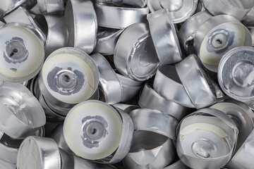 A lot of empty aluminum cups from burnt tea lights candles. Background, close-up.
