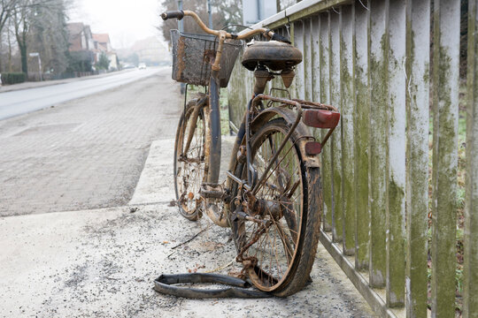 Ein altes, verlassenes, rostiges Fahrrad, das an einem Gel&auml;nder geparkt ist. Das Fahrrad lag einige Jahre im Fluss.