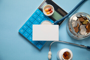 Jar of coins, stethoscope, calculator, pills. Empty space for your text