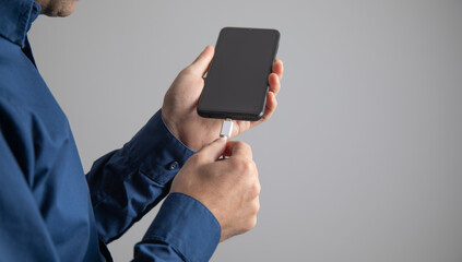 Man connect cable to smartphone. Charging