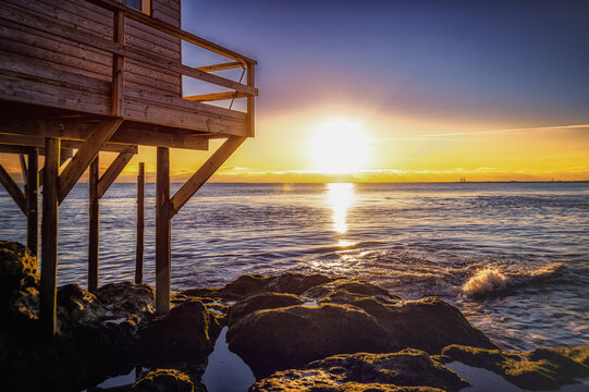 Cabane de p&ecirc;che sur pilotis au coucher du solei