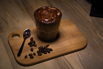 A creamy, frothy coffee served with a touch of elegance, complemented by rich coffee beans on a...