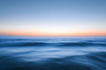 Sunset over calm ocean waters creates a serene atmosphere with vibrant colors on the horizon