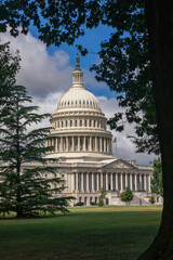 US Capitol Building in Washington, DC - Partial View on a sunny Summer Day with blue Sky; Trees in...