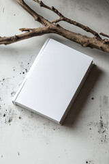 Product photography, a white paper magazine lying on a stone and wood branch, minimalism, a beige background, and bright light