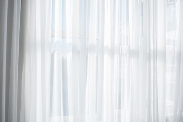 Soft light filters through sheer white curtains in a bright room