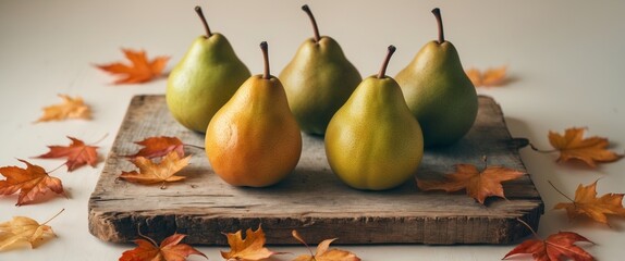 Ripe Pears with Green to Yellow Gradient on Wooden Board with Autumn Leaves and Soft Lighting.