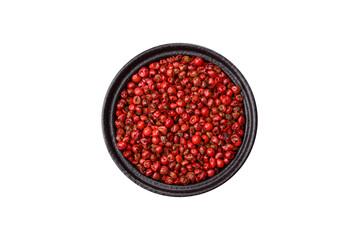 Spice, allspice peas in red or pink color in a bowl on a white background