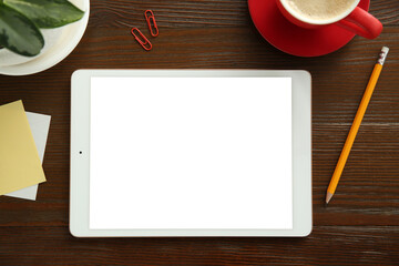 Flat lay composition with blank tablet on wooden table, space for text