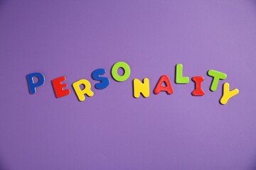 Word Personality made of colorful letters on purple background, top view