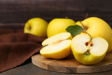 Fresh ripe yellow apples on wooden table, closeup. Space for text