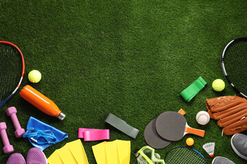 Naklejka premium Different sport equipment on artificial grass, flat lay. Space for text