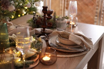 Christmas place setting with festive decor on wooden table in room