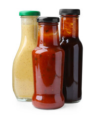 Different delicious sauces in glass bottles isolated on white