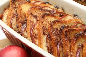 Delicious bread pudding in baking dish on table, closeup