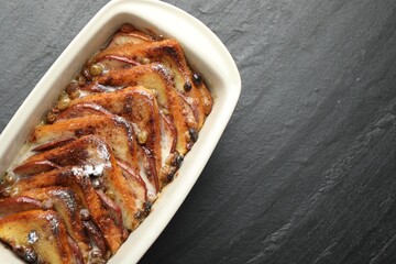Freshly baked bread pudding in baking dish on grey textured table, top view. Space for text