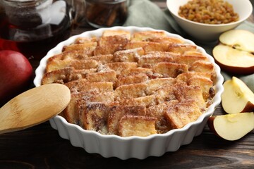 Delicious bread pudding with raisins, cinnamon and apples on wooden table, closeup