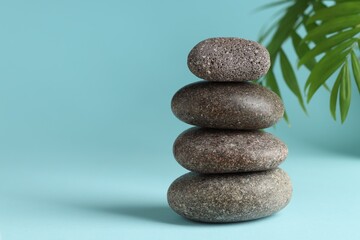 Stack of rocks on light blue background, space for text. Harmony and life balance