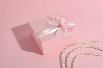 Beautiful wedding gift and pearl jewelry on pink background