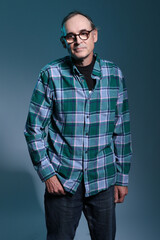 Handsome mature man wearing glasses & blue checked shirt, front view